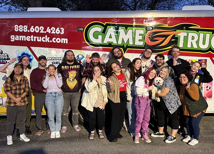 Family posing outside a GameTruck video game trailer