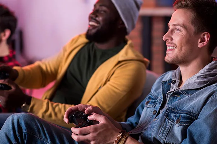 Two friends relaxed on a couch competing in a gaming session at a Gameplex lounge